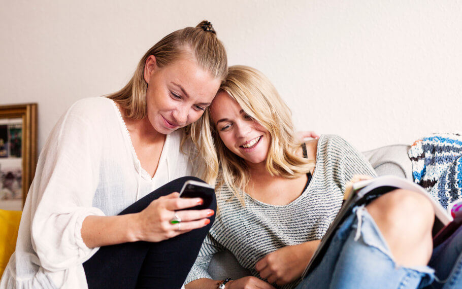 Two women look at a phone together.