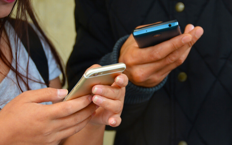 Two people are checking their messages on their phones.